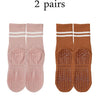 Two pairs of pink and brown grip socks for yoga and barre