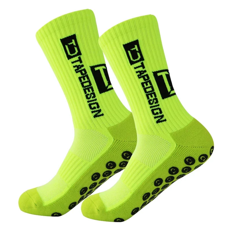 A pair of neon yellow performance sports socks with black text and grip dots.