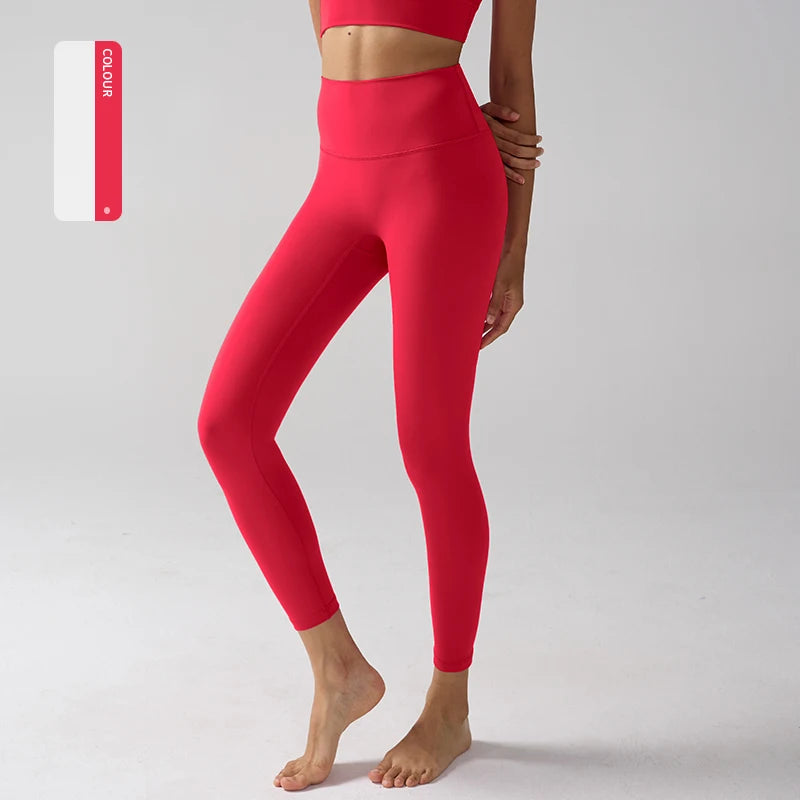Un mannequin porte un legging de performance rouge vif taille haute sur un fond gris clair.