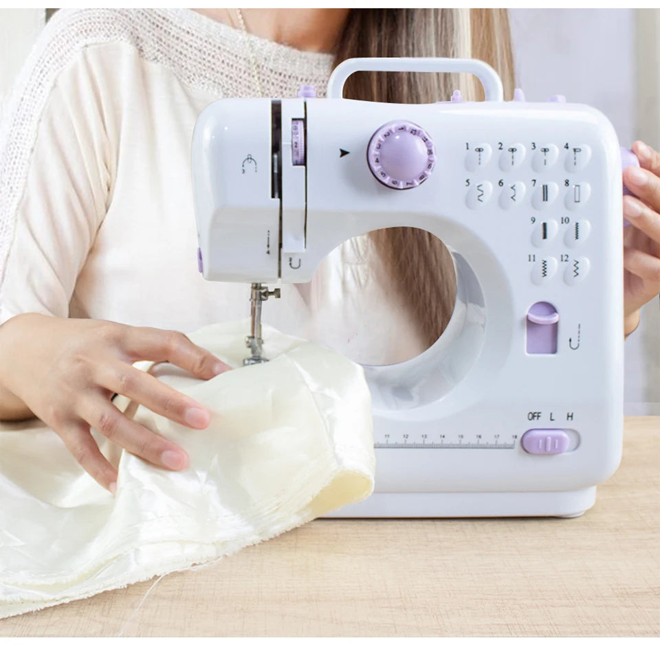 Eine Person benutzt eine weiße, portable Mini-Nähmaschine für Anfänger, um Stoff zu nähen.