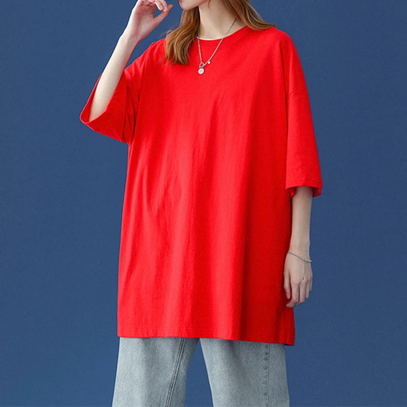 Eine Frau in einem leuchtend roten, oversized Baumwoll-T-Shirt vor einem dunkelblauen Hintergrund.