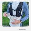 A person holds a black collapsible silicone water bottle against a white shirt, demonstrating the product.