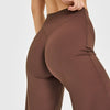 A close-up of a model wearing high-waist yoga pants in a brown color.