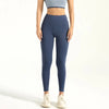 A person wearing dark blue seamless high-waist yoga leggings and a light gray cropped top.