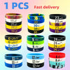 A collection of black, yellow, blue, and pink silicone wristbands for sports and fashion.
