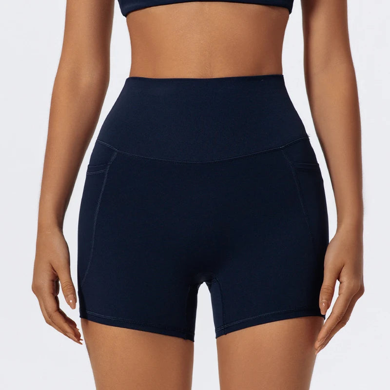 A model wearing navy blue high-waist yoga and workout shorts.
