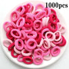 Haufen von 1000 rosa und roten Nylon-Elasthebändchen für Pferdeschwänze und Zöpfe.