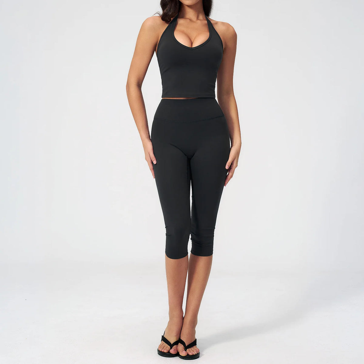 A woman wearing a black women's premium fitness tracksuit top and leggings.