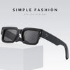 Black square sunglasses resting on a white box.