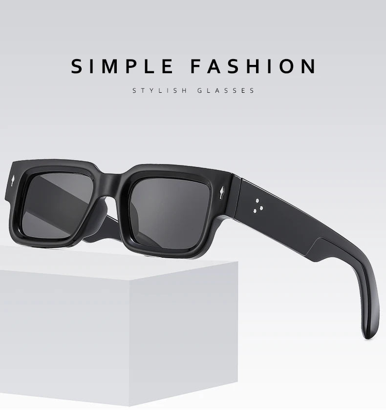 Black square sunglasses resting on a white box.