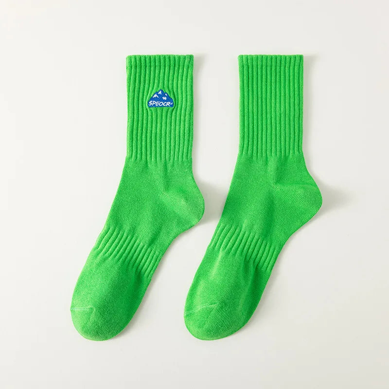 A pair of bright green men's athletic crew socks with a blue embroidered logo.