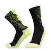 A pair of black sports socks with neon yellow accents and anti-slip silicone grips for football.