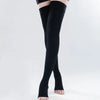 A person is wearing black medical compression stockings on their legs.