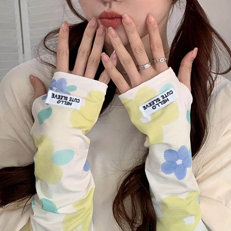 A person is wearing white and yellow floral ice silk sun protection arm sleeves on their arms.
