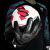 A black and red latex goalkeeper glove is shown being held against a dark shirt.