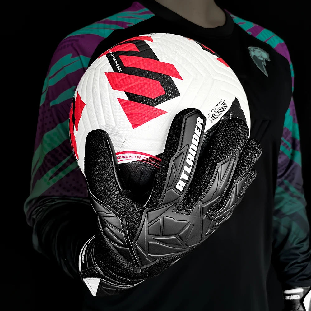 A black and red latex goalkeeper glove is shown being held against a dark shirt.