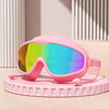 Gafas de natación antiempañante rosas con lente arcoíris vibrante sobre un soporte circular rosa claro.