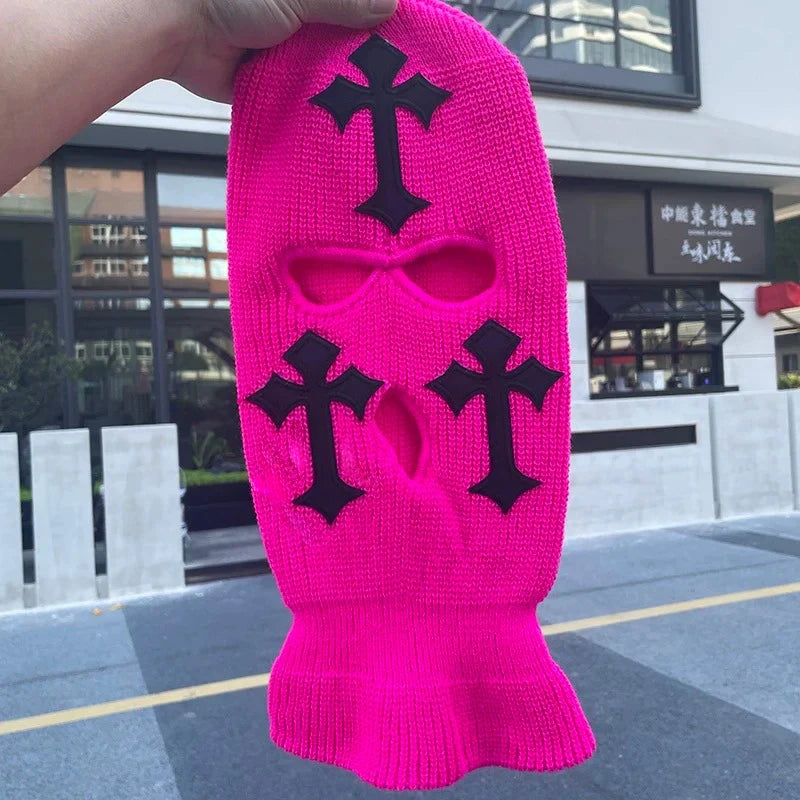 A bright pink tactical knit balaclava beanie hat featuring black cross embroidery.