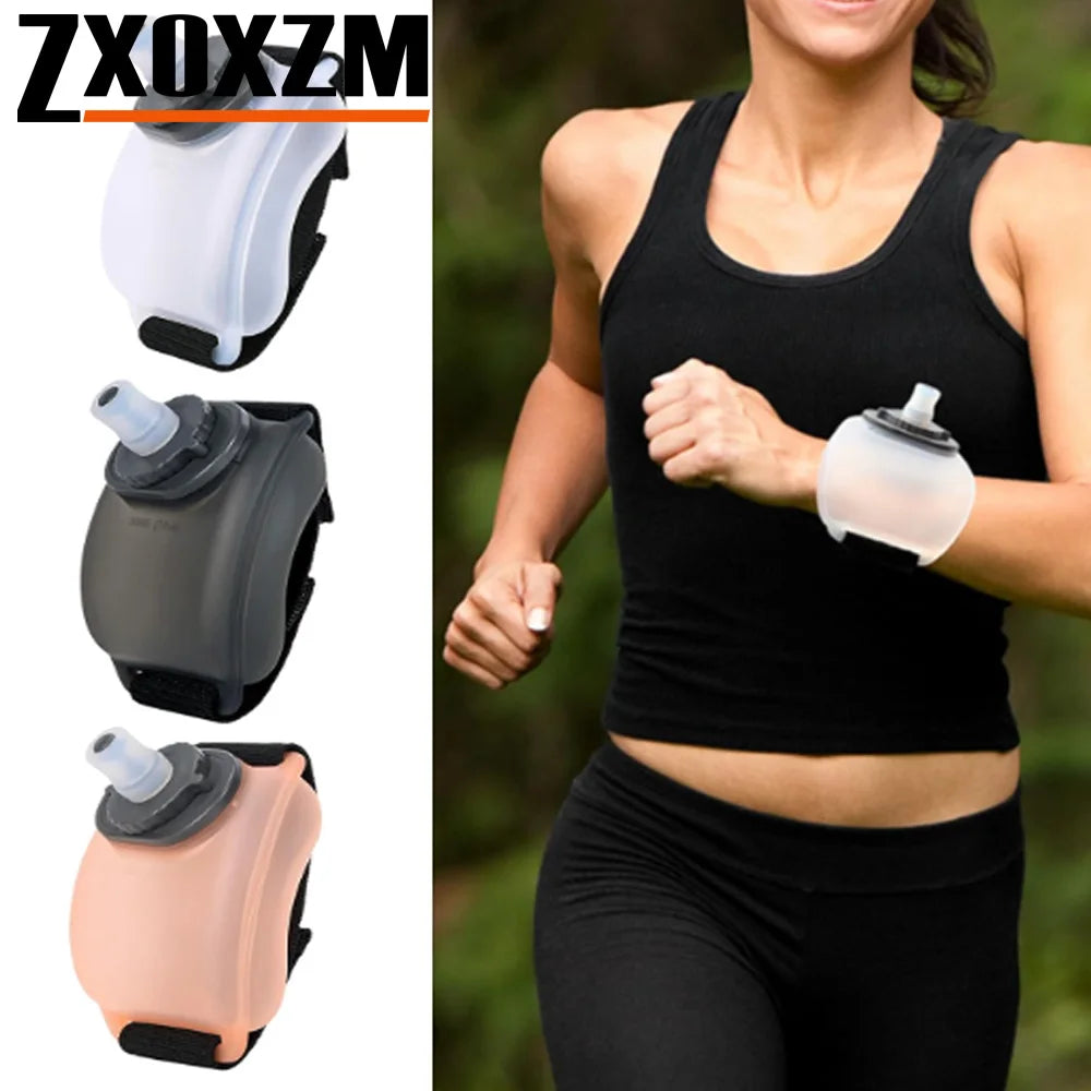 A woman is exercising while wearing a black tank top and black leggings, holding a clear silicone hydration bottle on her wri