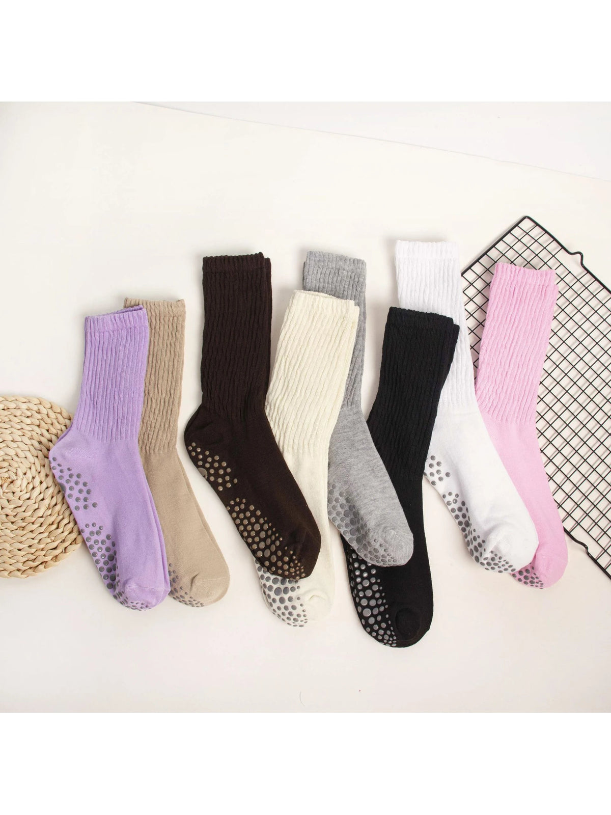 A collection of mid-calf yoga and pilates socks in various colors including purple, beige, gray, black, and white.