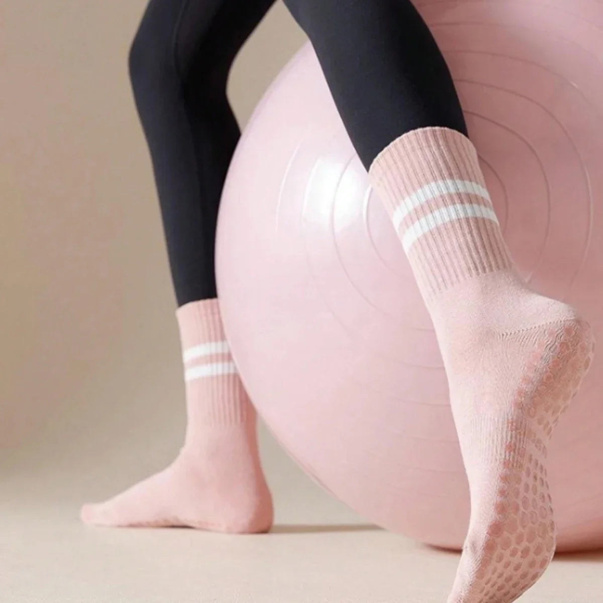 Pink Pilates grip socks worn by a person, shown in a close-up angle.