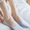 A pair of light purple silicone anti-slip summer socks resting on white fabric.