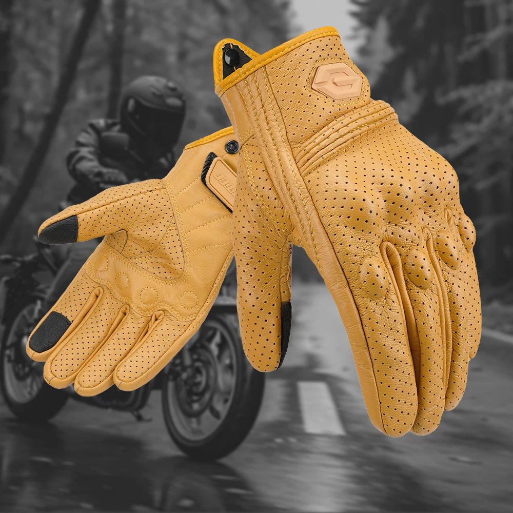 A pair of tan vintage leather motorcycle riding gloves are shown in flight against a blurred outdoor background.