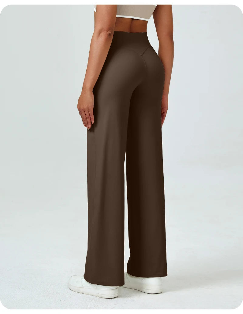 A woman is modeling high waisted brown yoga pants with a white top.