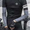 Una persona vistiendo ropa deportiva negra y mangas grises para hacer deporte.