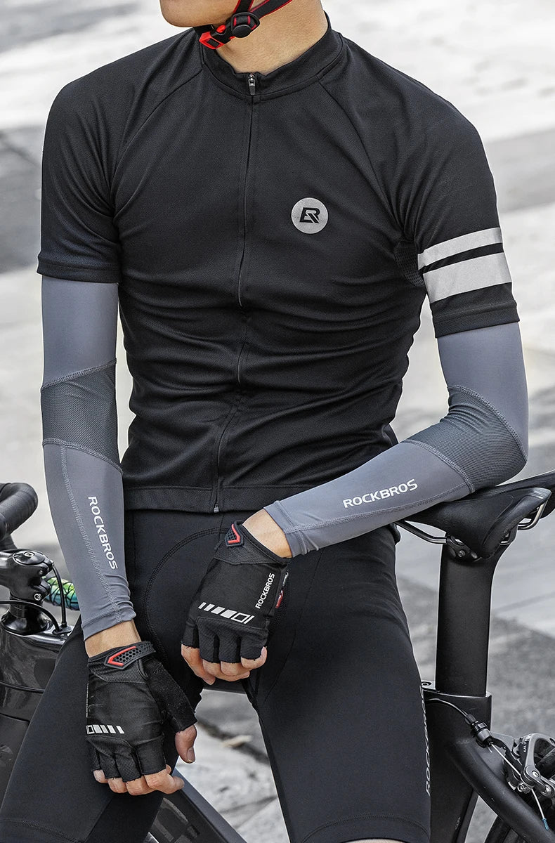 Una persona vistiendo ropa deportiva negra y mangas grises para hacer deporte.