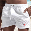 White quick-drying men's swim shorts worn by a person, showing the fabric and design details.