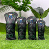 A set of four black golf club head covers featuring a silhouette of a golfer and the text CHANGE 1961 on a green grassy surfa