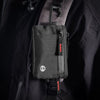 A black slim RFID blocking wallet is clipped onto a dark jacket or bag.