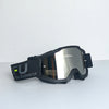 A pair of black sport-grade skiing goggles with reflective lenses and a black strap resting on a white surface.