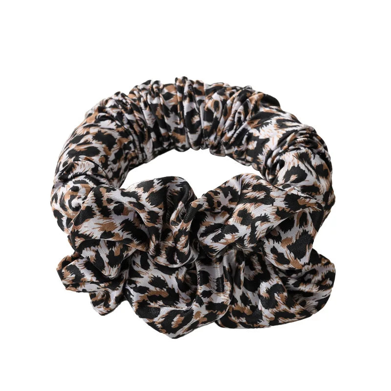 A black and brown leopard print heatless curling rod headband tied in a voluminous knot.