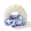 A headband made of gathered, silky fabric in light cream and soft lavender colors.