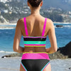 A woman wearing a color-block zigzag three-piece swimsuit set standing on a beach.