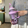 A person holds a purple plastic drinking cup labeled Ice Cream in a light gray cardigan.