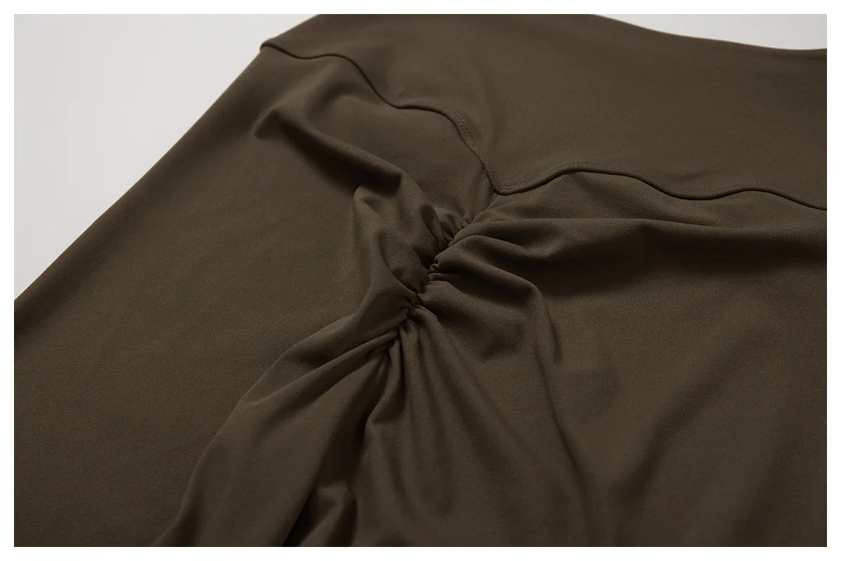 A close-up of a dark brown women's performance tracksuit set fabric draped and folded.