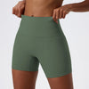 Short de yoga taille haute en vert olive et compression porté par une personne.