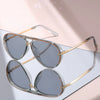 Pair of classic gradient aviator sunglasses with gold-toned frames displayed on a light surface.