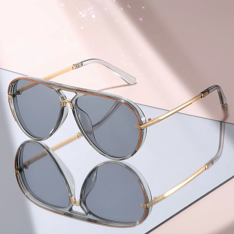 Pair of classic gradient aviator sunglasses with gold-toned frames displayed on a light surface.