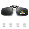 A pair of black polarized driving sunglasses with various lens sizes shown alongside a ruler.