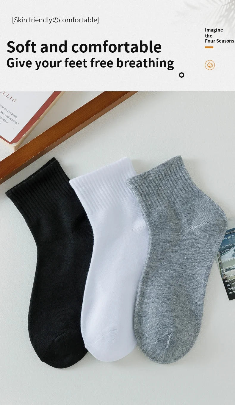 Ein Set aus drei weichen und bequemen Socken in Schwarz, Weiß und Grau auf einer hellen Oberfläche.