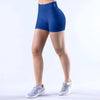 A woman wearing royal blue seamless high-waisted yoga shorts and white athletic shoes.
