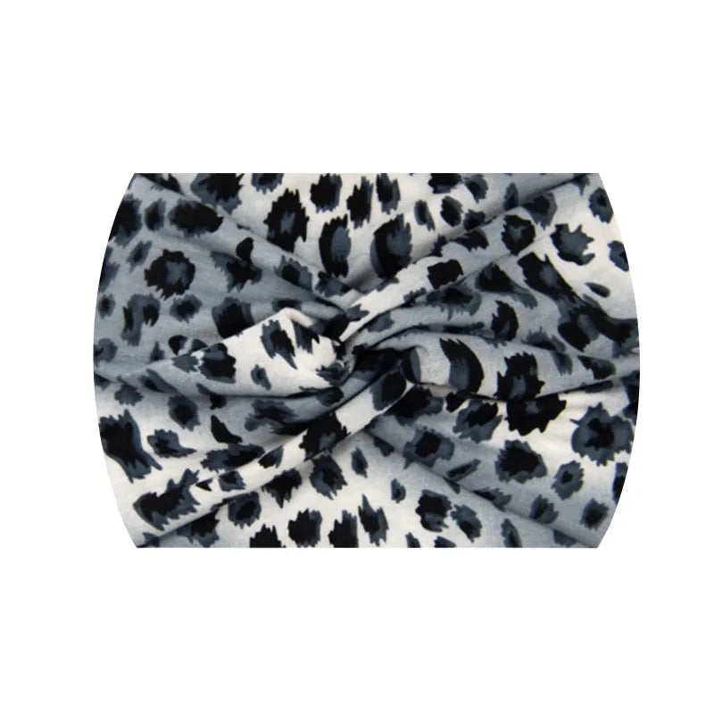 A close-up of a grey and black leopard print wide knotted headband.