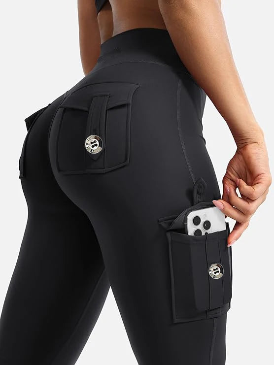 A close-up of black high-waisted flared fitness pants featuring multiple pockets and hardware.