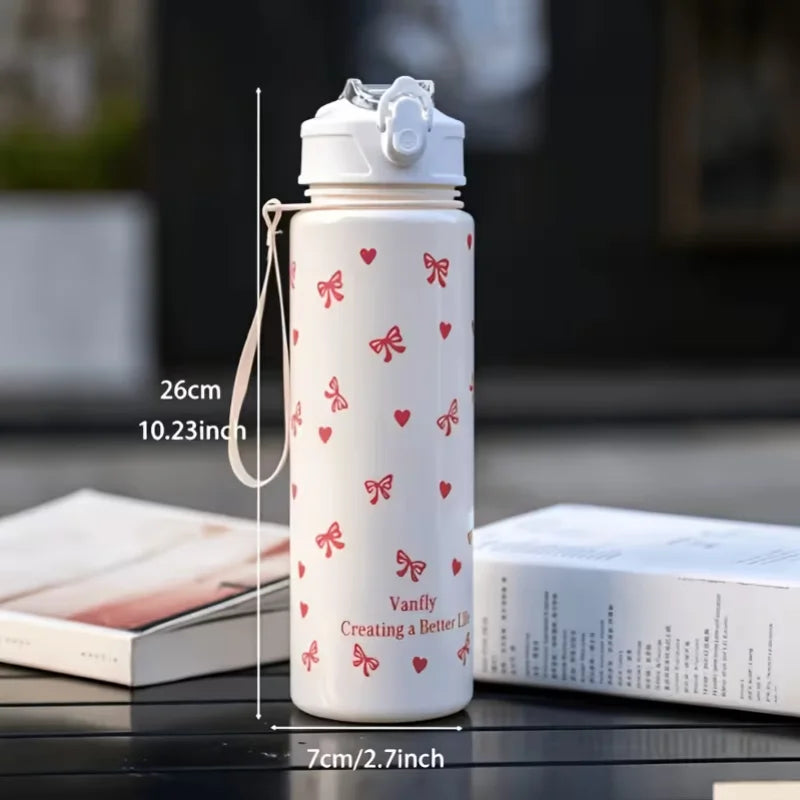 A white tumbler with a pink heart and bow pattern is shown next to a box, measuring 26cm tall.