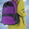 A young man wearing a lime green jacket and black pants carrying a purple multi-sport fitness backpack.