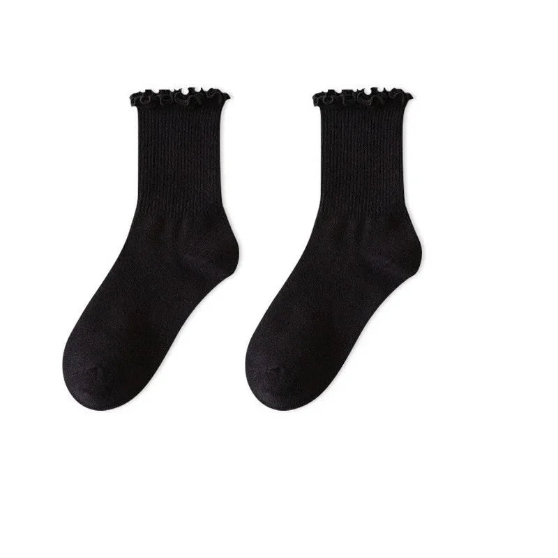 A pair of black cotton ruffle ankle socks shown against a white background.